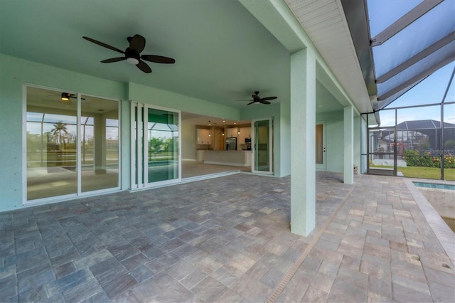 view of patio featuring glass enclosure and ceiling fan