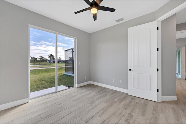 empty room with ceiling fan and light hardwood / wood-style floors