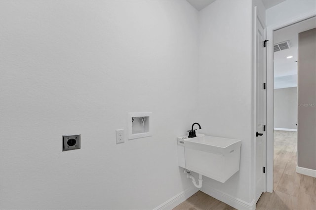 laundry area with washer hookup, electric dryer hookup, light wood-type flooring, and sink