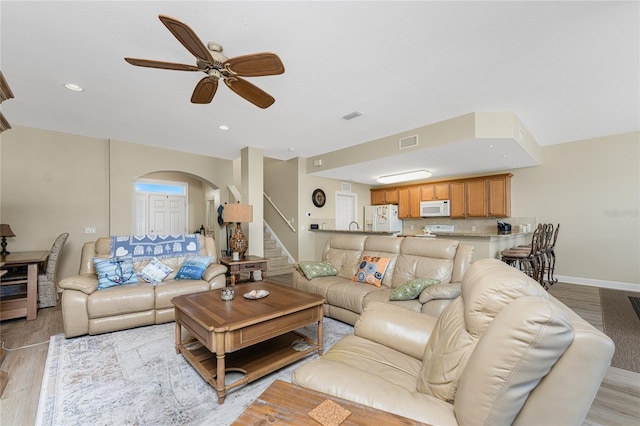 living room with light hardwood / wood-style floors and ceiling fan