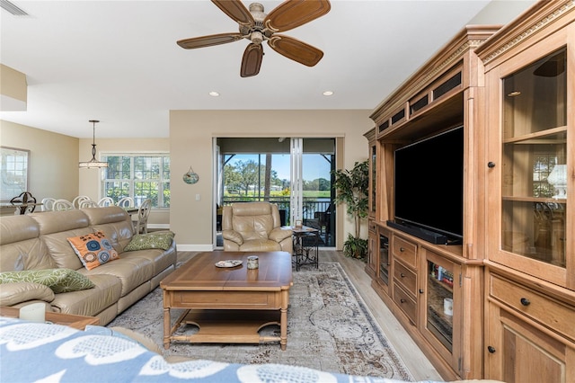 living room with light hardwood / wood-style floors and ceiling fan