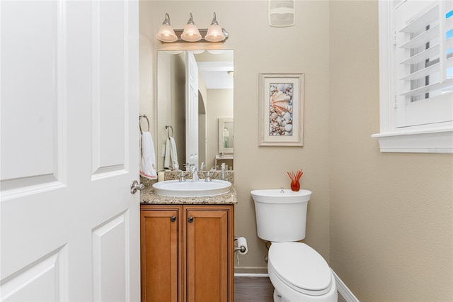 bathroom featuring toilet, hardwood / wood-style floors, and vanity