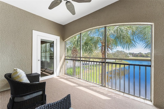 sunroom with lofted ceiling, a water view, and ceiling fan