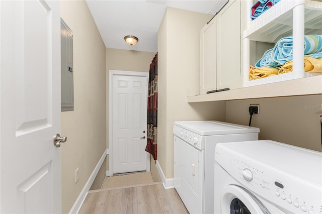 clothes washing area with cabinets, washer and dryer, hookup for an electric dryer, and light wood-type flooring