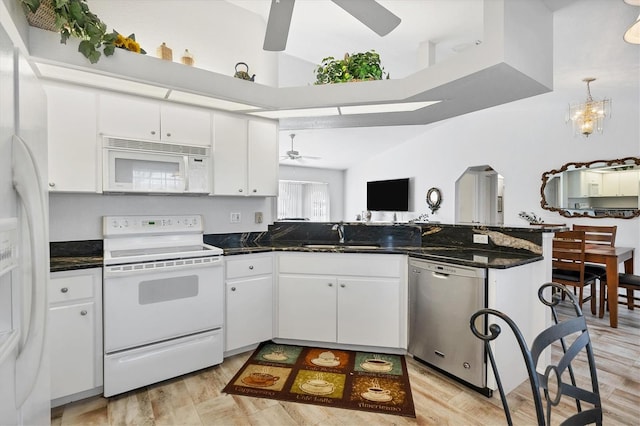 kitchen featuring white appliances, sink, white cabinets, light hardwood / wood-style floors, and ceiling fan with notable chandelier