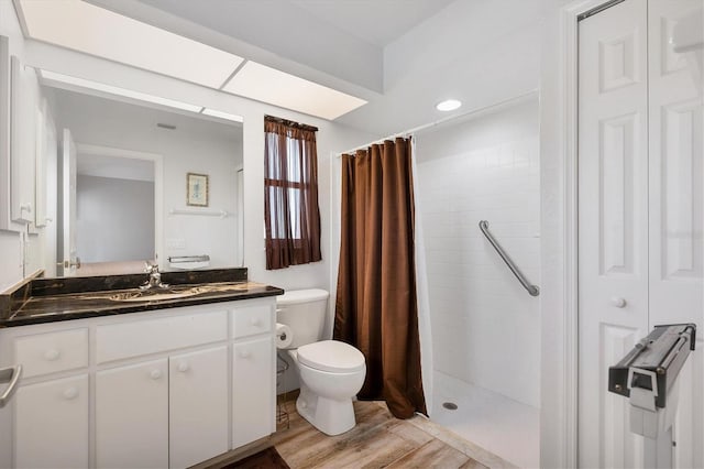 bathroom featuring walk in shower, toilet, vanity, and wood-type flooring