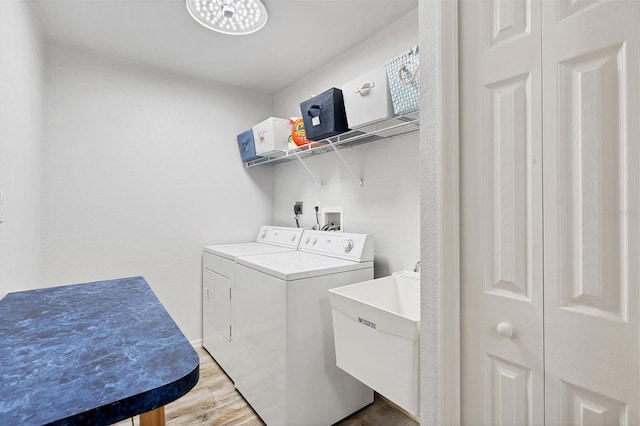 washroom with electric dryer hookup, washer hookup, independent washer and dryer, light wood-type flooring, and sink