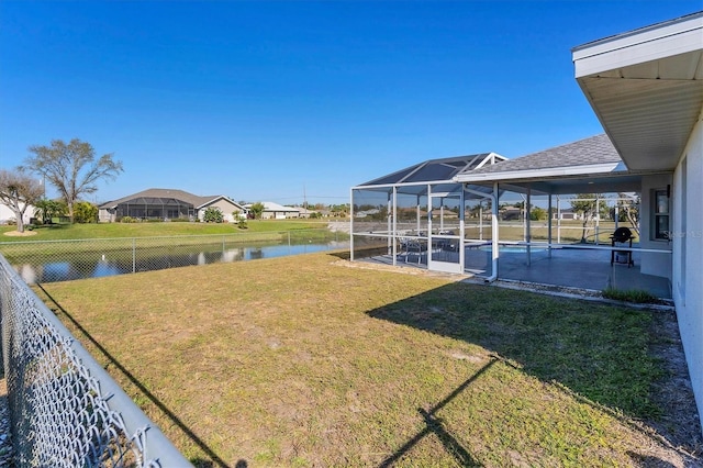 view of yard with glass enclosure and a water view