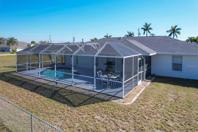 rear view of house featuring a lawn, a fenced in pool, a patio, and a lanai