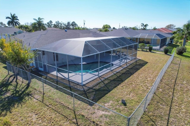 view of swimming pool with a lanai and a yard