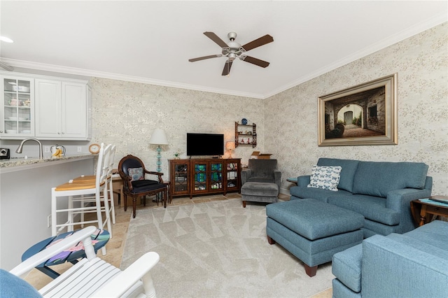 carpeted living room with ornamental molding, ceiling fan, and sink