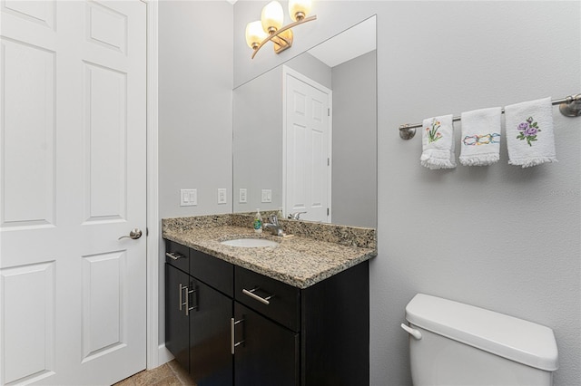 bathroom with toilet and large vanity