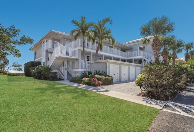 view of front of house featuring a balcony and a front lawn