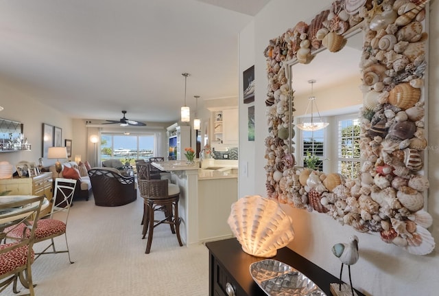 living room with light carpet, plenty of natural light, ceiling fan, and sink