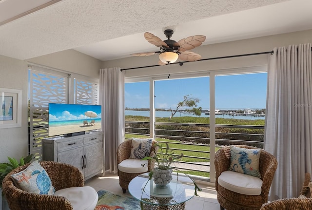 sunroom featuring a water view and ceiling fan