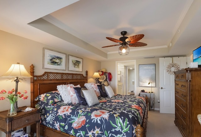 bedroom with carpet floors, ensuite bathroom, a raised ceiling, and ceiling fan