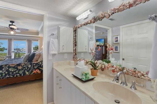 bathroom with double sink vanity, a textured ceiling, and ceiling fan