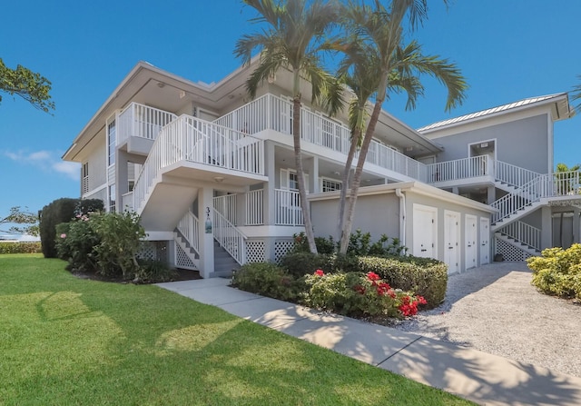 view of front of home with a balcony and a front lawn