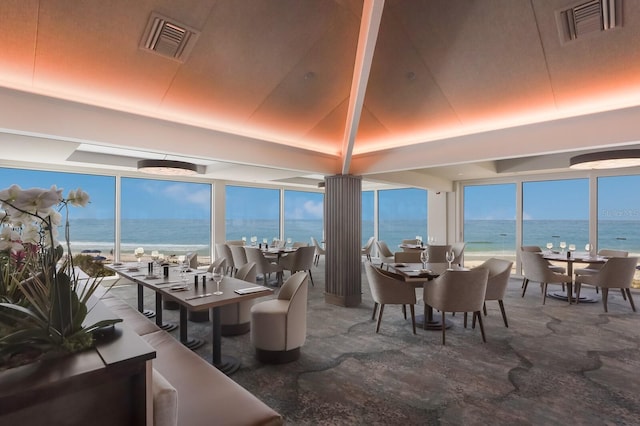 living room with a tray ceiling and a water view