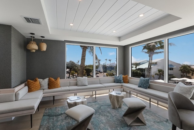 living room with a tray ceiling and wood-type flooring