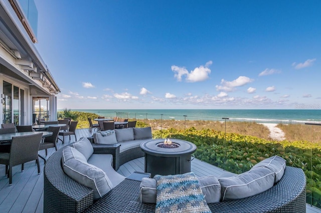 deck featuring an outdoor living space with a fire pit and a water view