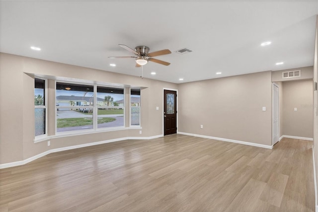 empty room with recessed lighting, baseboards, visible vents, and light wood finished floors