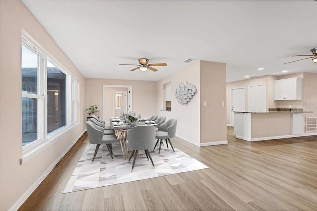 dining area with a ceiling fan, visible vents, light wood-style flooring, and baseboards