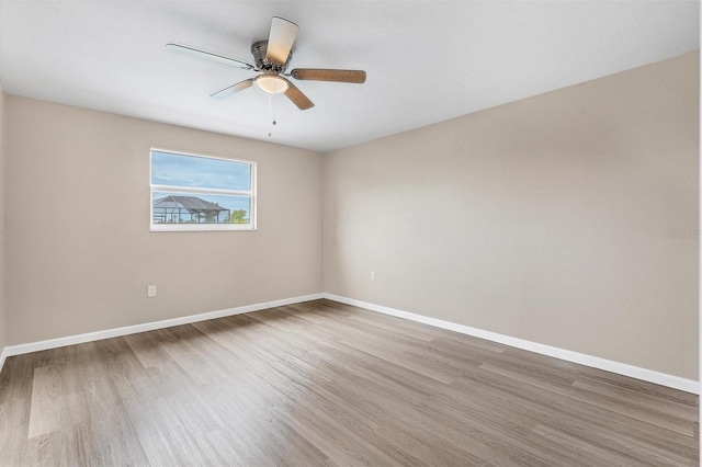 unfurnished room featuring ceiling fan, wood finished floors, and baseboards