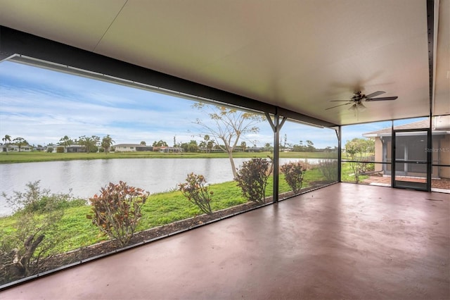 unfurnished sunroom featuring a water view and ceiling fan