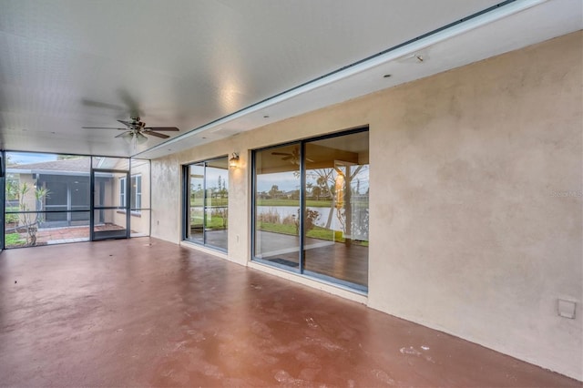 unfurnished room featuring a water view, concrete floors, and a ceiling fan