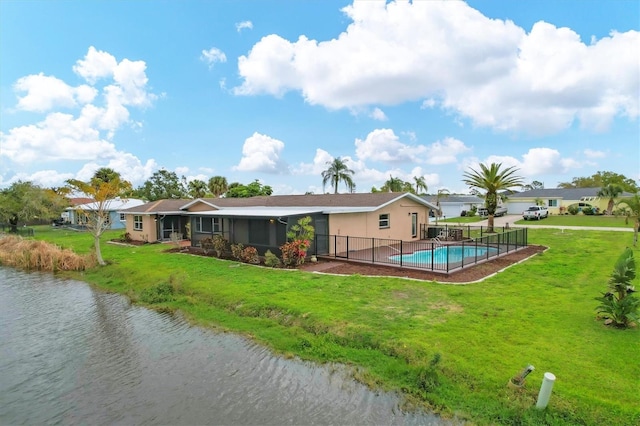 back of property featuring a water view and a yard