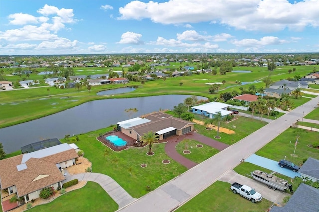 birds eye view of property with golf course view and a water view