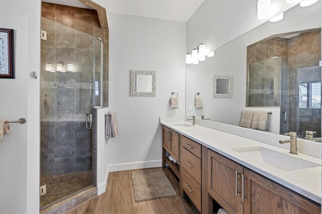 bathroom featuring hardwood / wood-style flooring, double sink, an enclosed shower, and oversized vanity