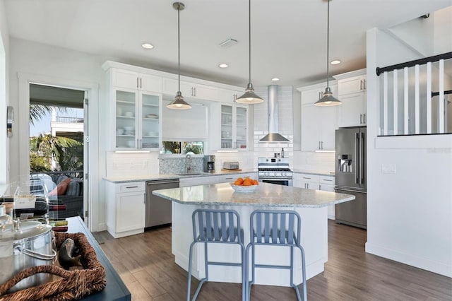 kitchen with backsplash, a breakfast bar, decorative light fixtures, and appliances with stainless steel finishes