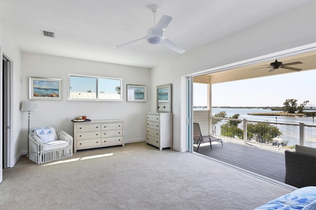 carpeted bedroom with a water view and ceiling fan