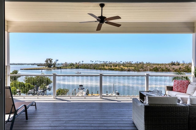 deck with an outdoor living space, ceiling fan, and a water view