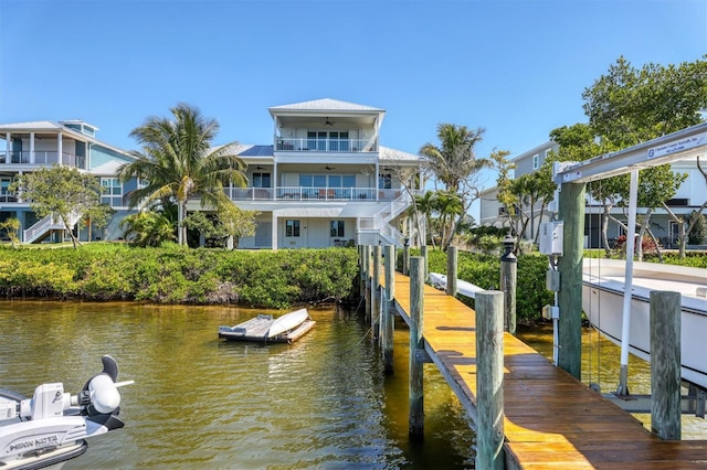 dock area with a water view and a balcony