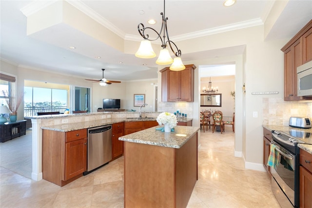 kitchen with decorative light fixtures, backsplash, ceiling fan with notable chandelier, appliances with stainless steel finishes, and a center island