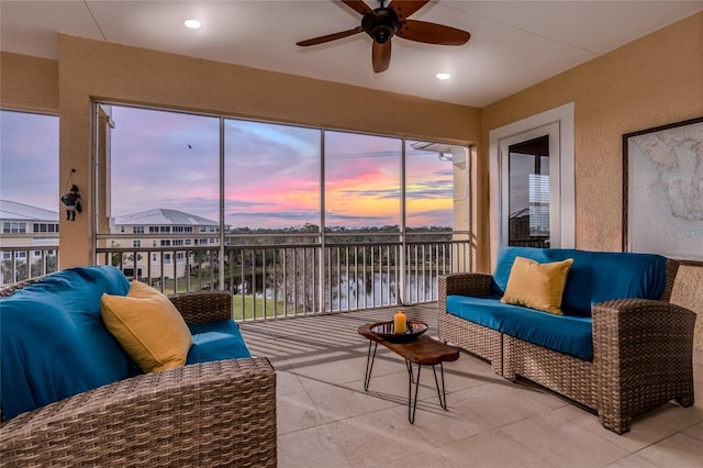 sunroom / solarium with a water view and ceiling fan