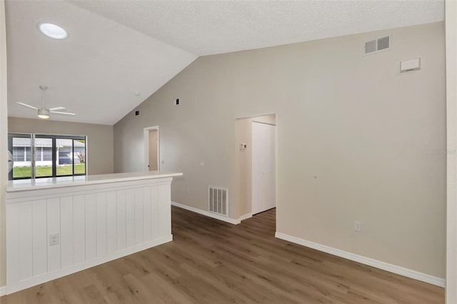 empty room with lofted ceiling, dark hardwood / wood-style floors, and ceiling fan