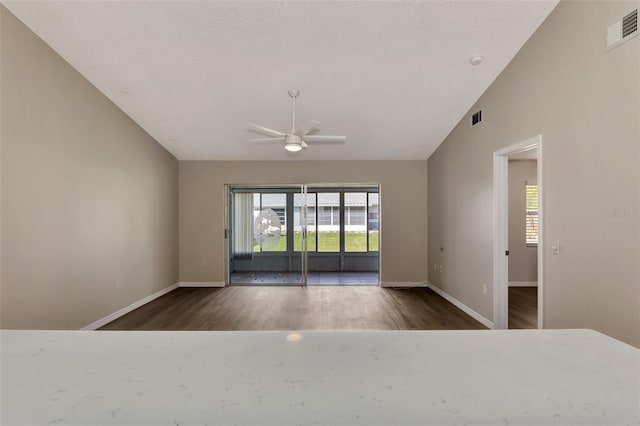 empty room with ceiling fan, dark wood-type flooring, and lofted ceiling