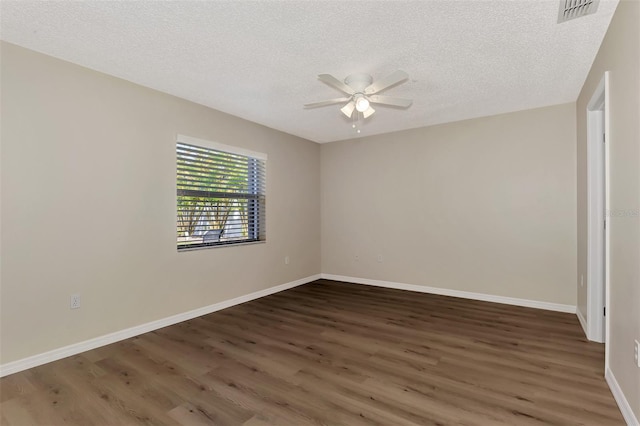 spare room with ceiling fan, dark wood-type flooring, and a textured ceiling