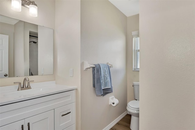 bathroom featuring toilet, wood-type flooring, and large vanity