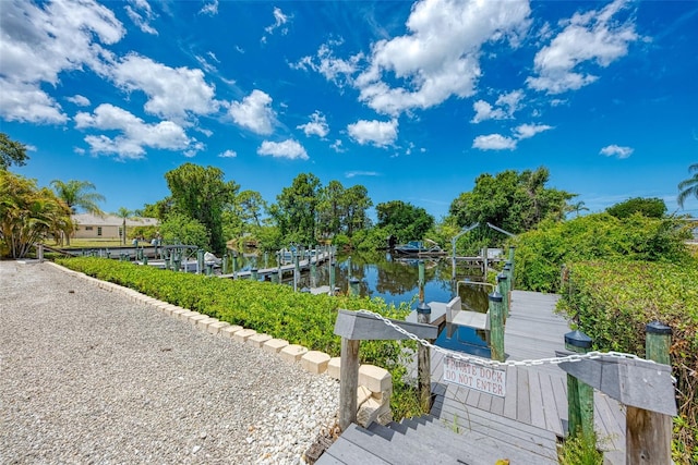 surrounding community featuring a water view and a boat dock