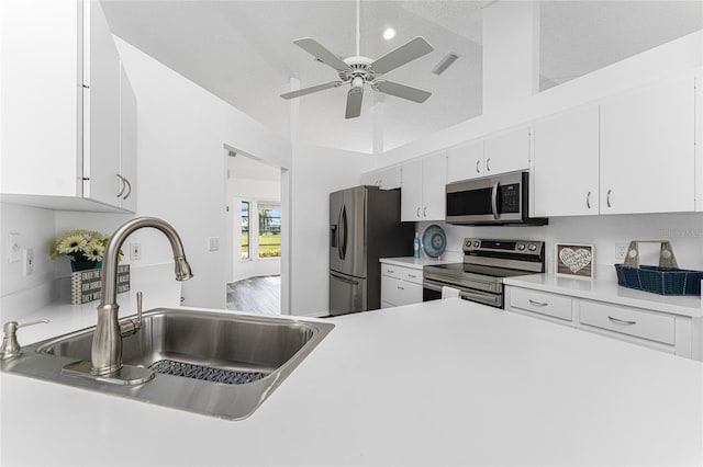 kitchen featuring appliances with stainless steel finishes, a textured ceiling, ceiling fan, sink, and white cabinetry