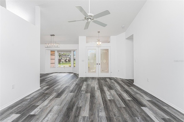 unfurnished living room featuring ceiling fan with notable chandelier, french doors, dark hardwood / wood-style flooring, and a textured ceiling