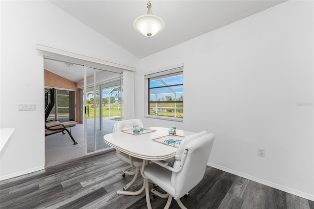 dining space with dark wood-type flooring and vaulted ceiling