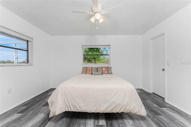 bedroom with ceiling fan, dark hardwood / wood-style floors, and a textured ceiling