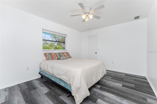 bedroom featuring a textured ceiling, dark hardwood / wood-style flooring, and ceiling fan