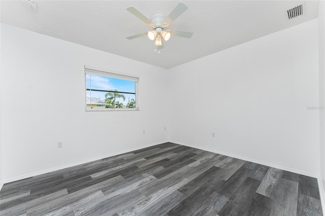 empty room featuring dark hardwood / wood-style floors, ceiling fan, and a textured ceiling